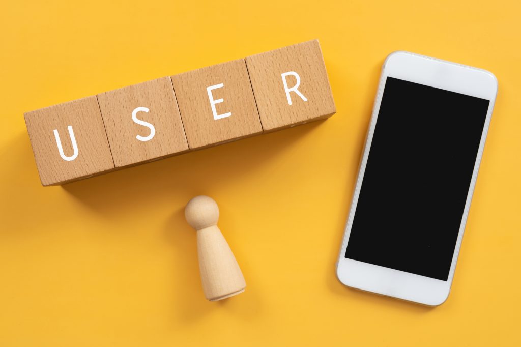 ユーザー、利用者、サービス｜「USER」と書かれた積み木と人型オブジェとスマートフォン